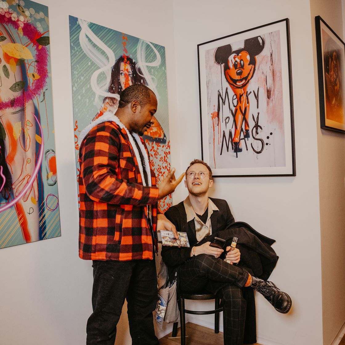 Visitantes en una galería con cuadros de colores