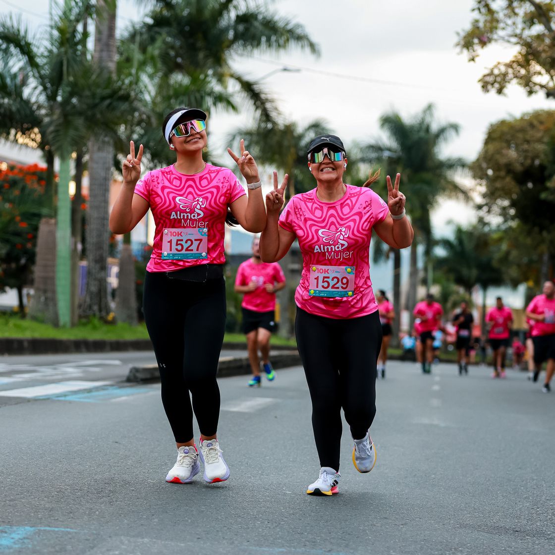 Corredoras con playeras rosas en una carrera con causa