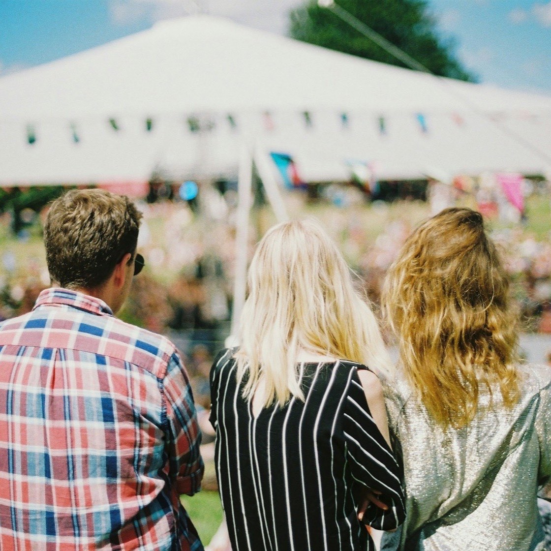 Amigos caminando hacia la entrada de un festival al aire libre