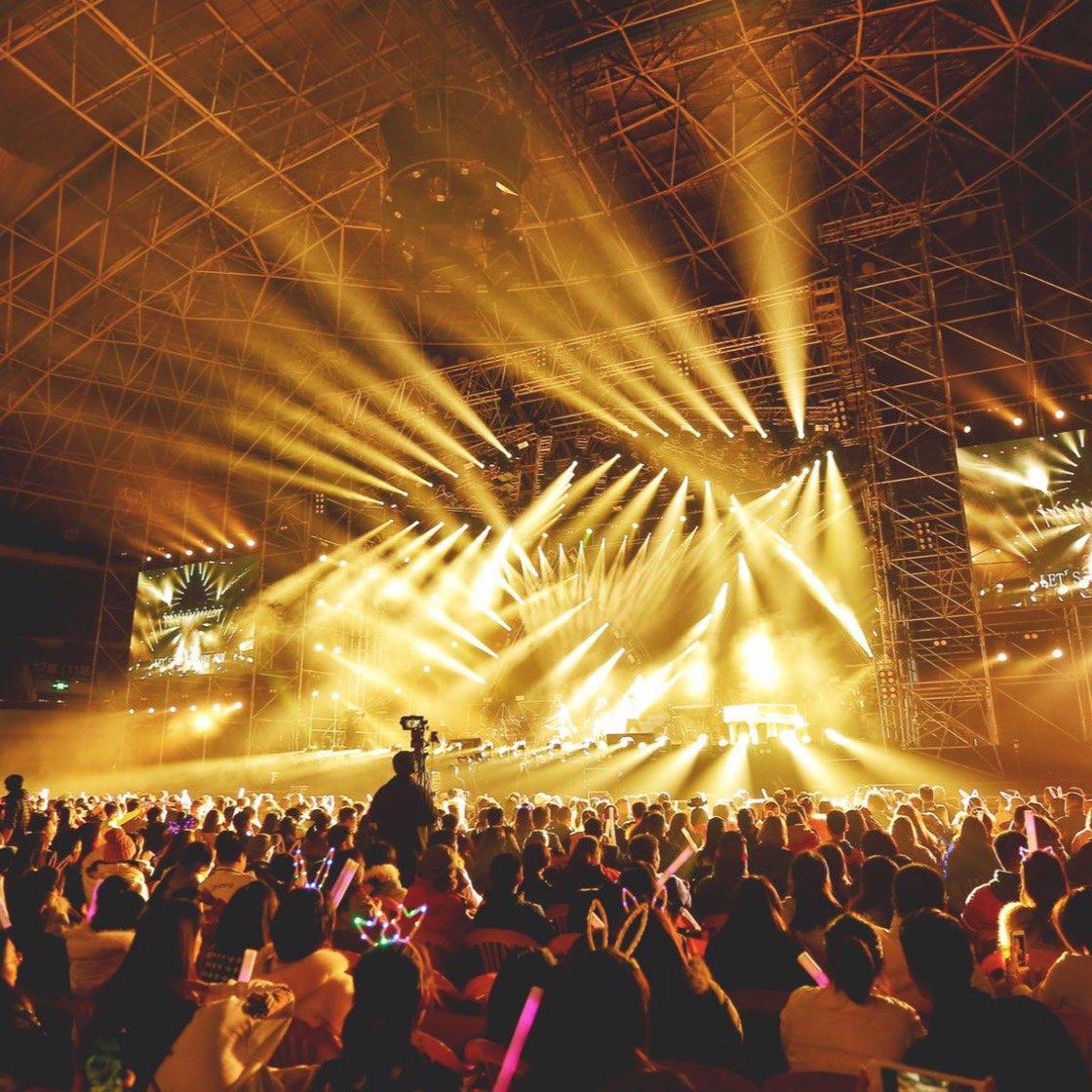 Público frente al escenario iluminado de un concierto