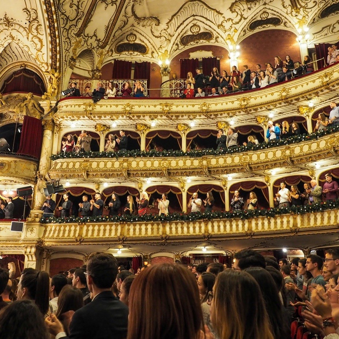 Teatro lleno con palcos dorados y el público en sus butacas