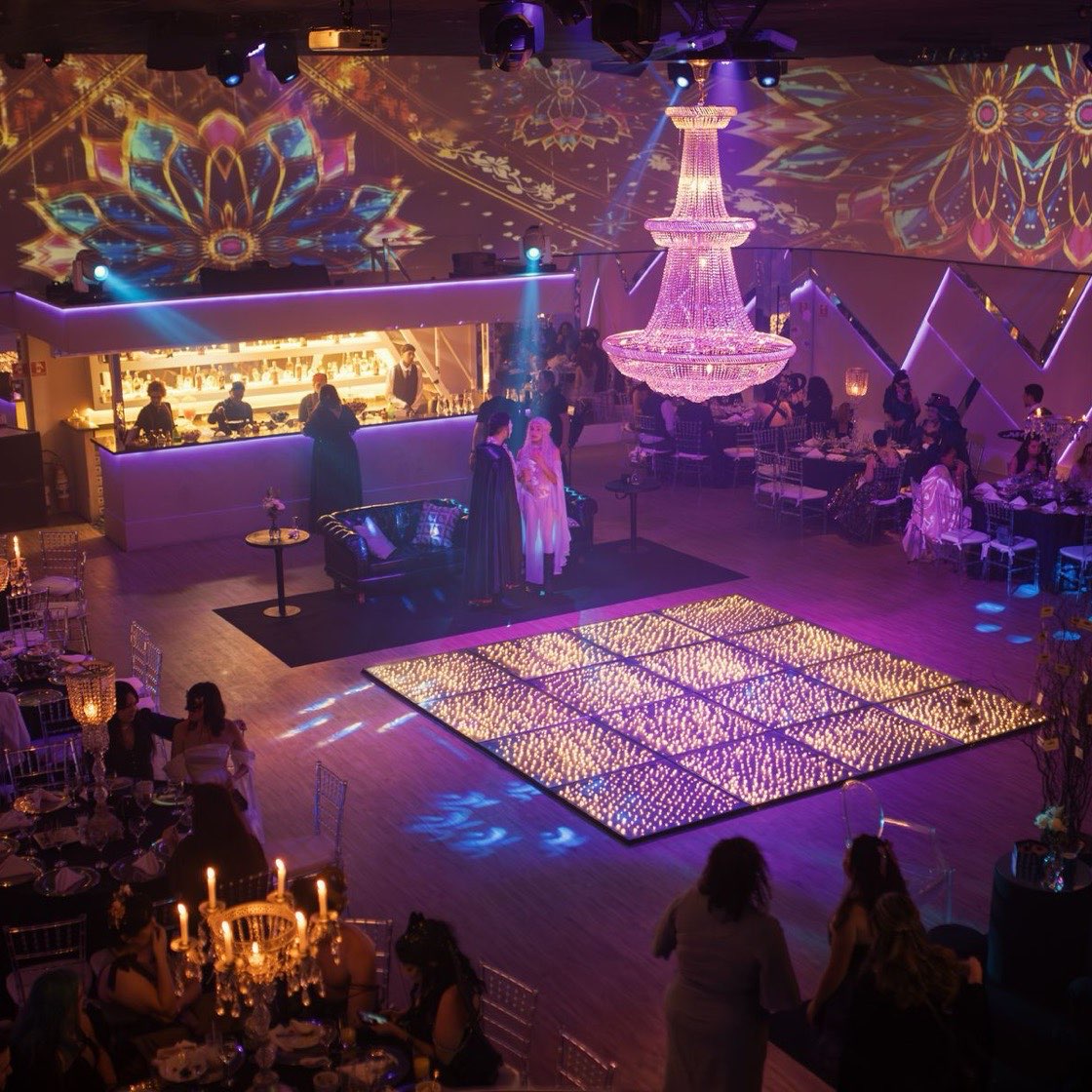 Salón de gala con luces de colores y mesas puestas