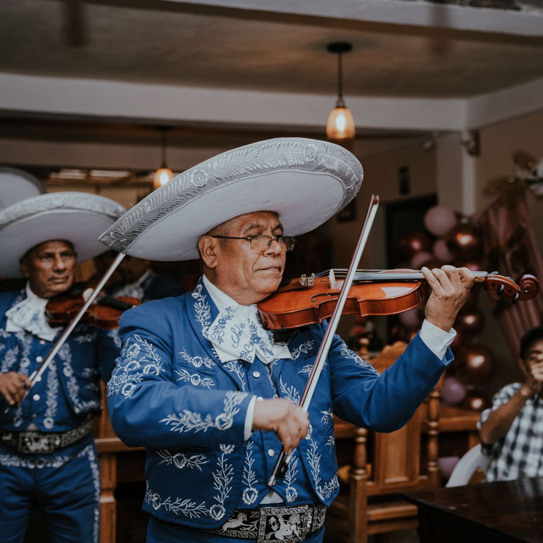 Mariachis tocando violines con sombrero