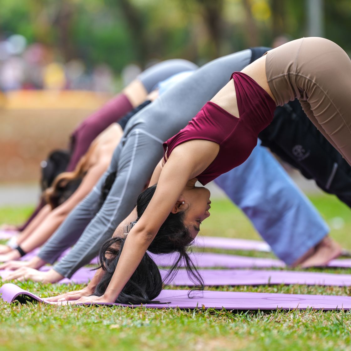 Grupo haciendo yoga sobre tapetes al aire libre