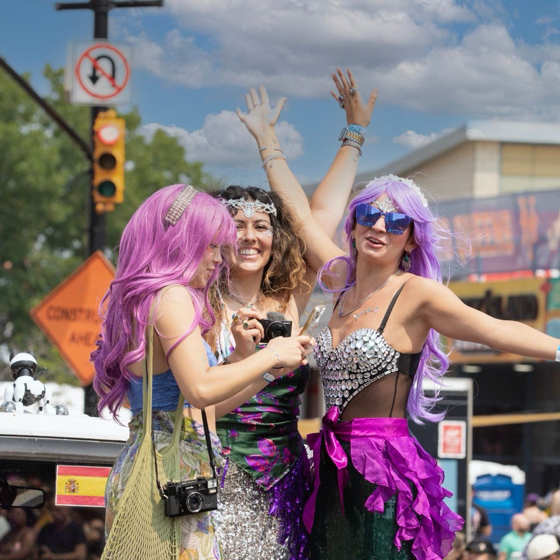 Amigas celebrando en un festival con disfraces de colores