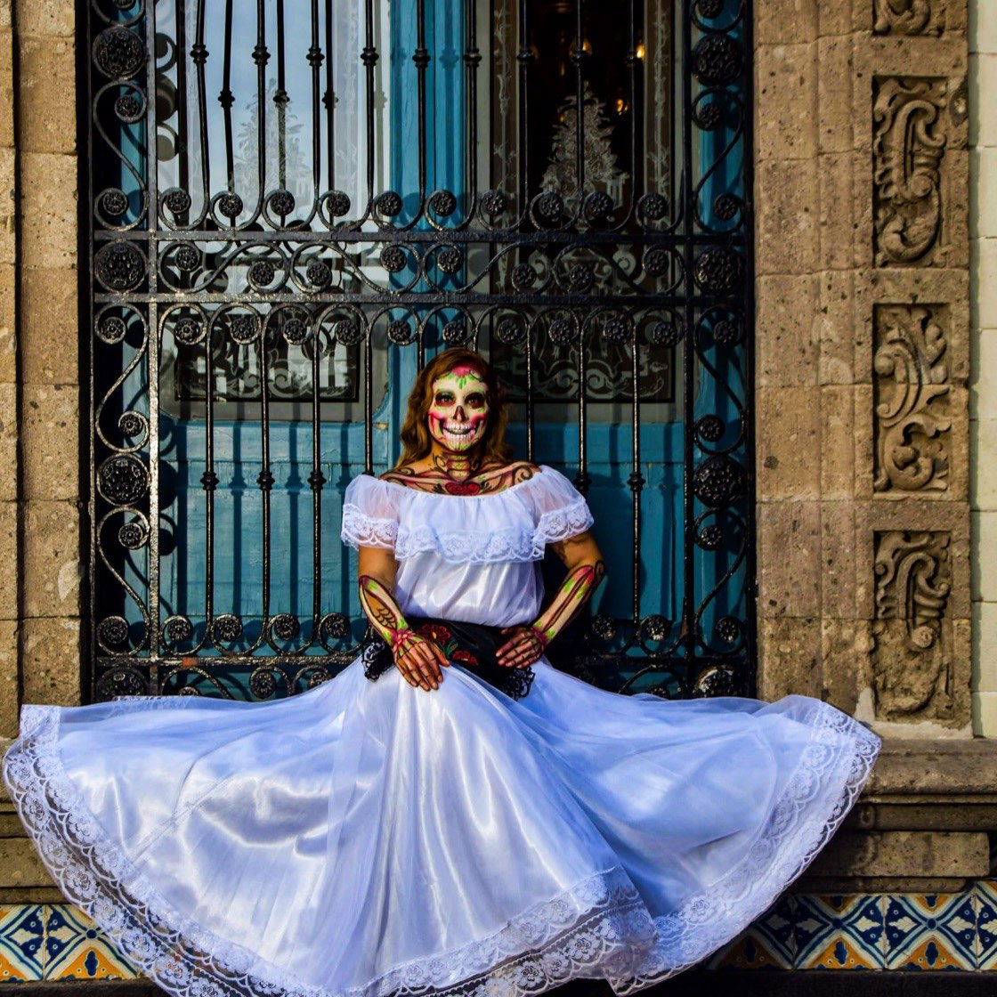 Mujer caracterizada de catrina con vestido de colores