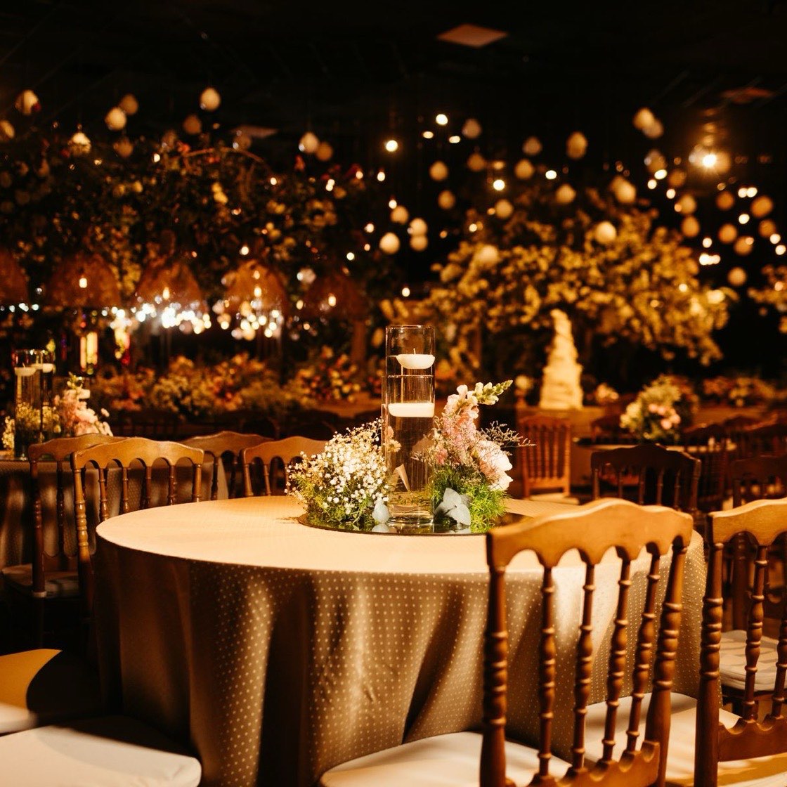 Salón de gala de noche con mesas redondas y luces cálidas
