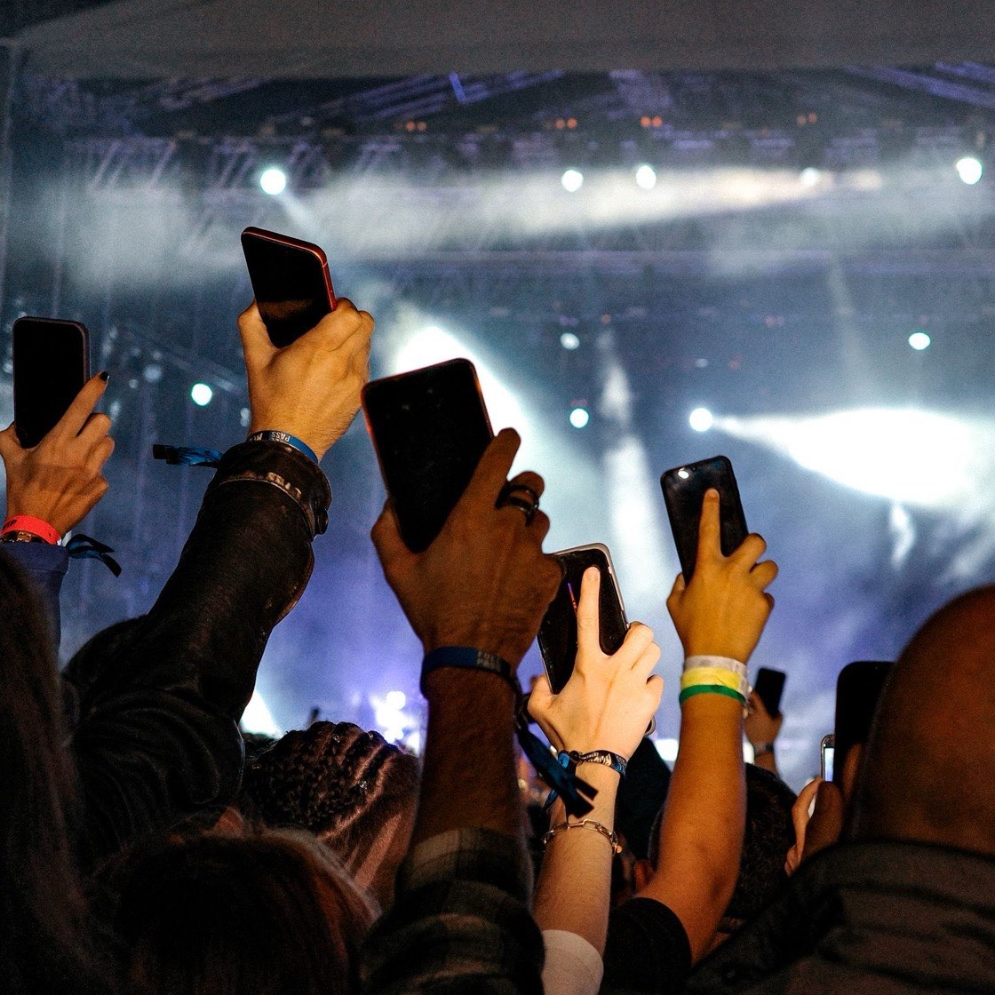 Público levantando sus celulares en un concierto
