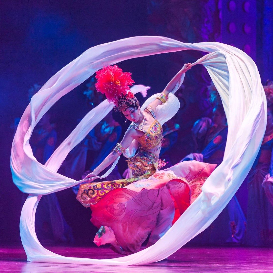 Bailarina con listones sobre un escenario de colores
